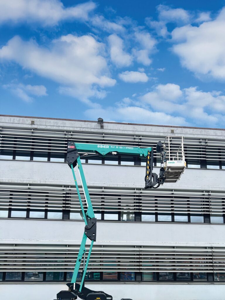 IM R 49 / 15 DA Pro set up on outriggers beside a stadium facade